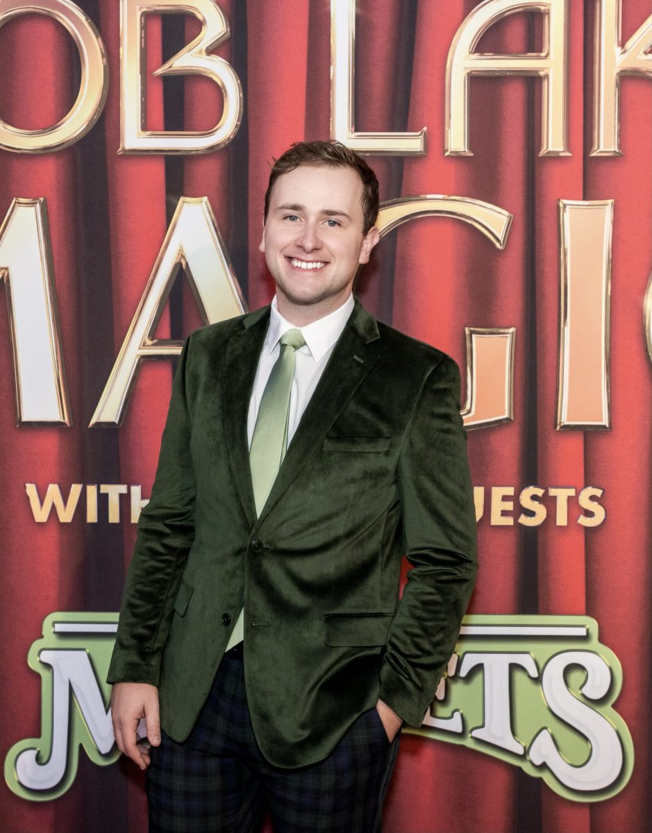 Man smiling wearing green suit